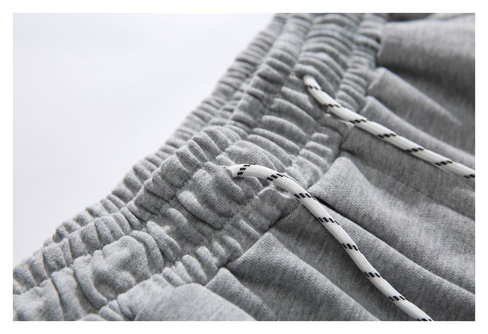 Close-up of the gathered waistband and white drawstring with black accents on gray shorts.