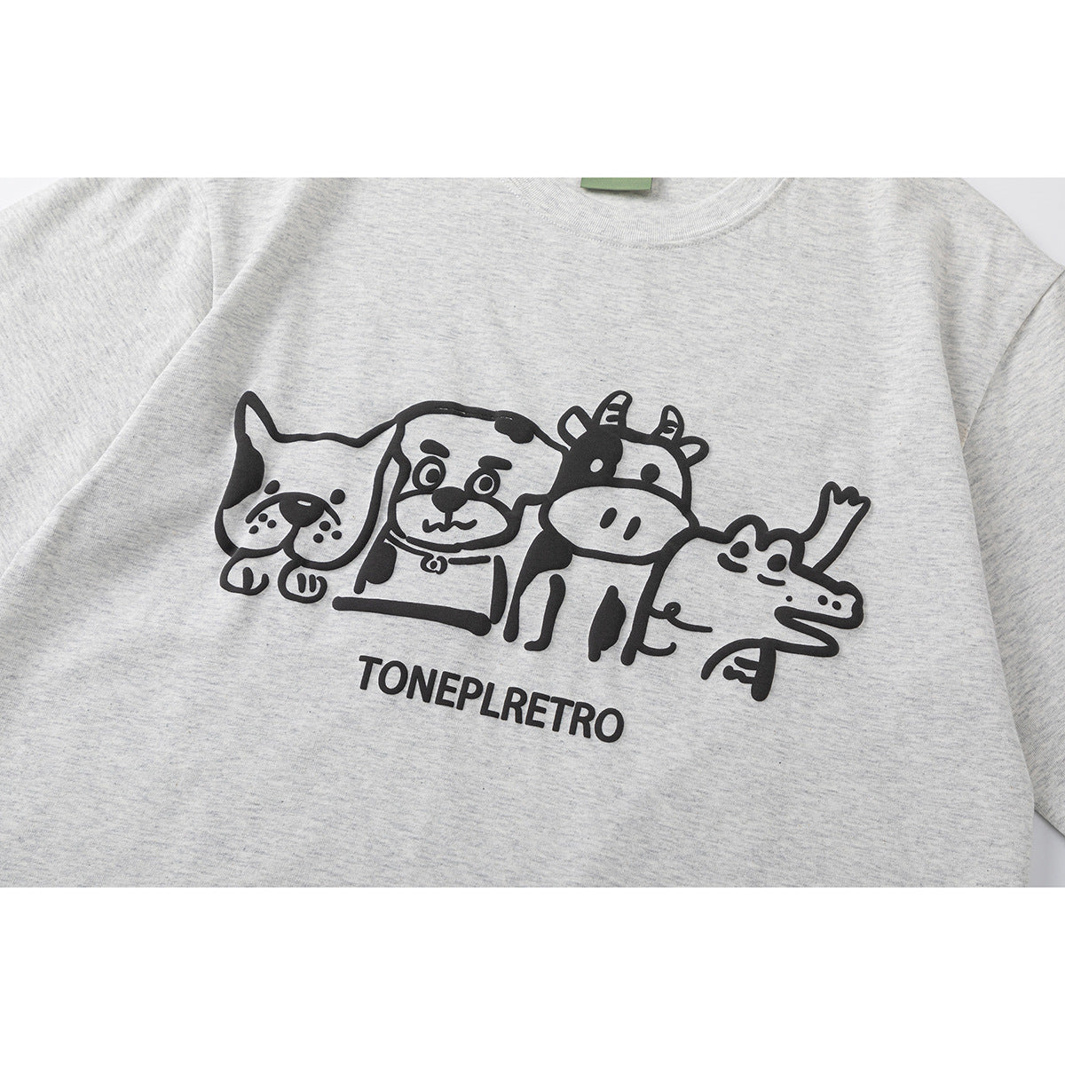 Close-up of a heather gray T-shirt with a black cartoon animal group graphic and text.