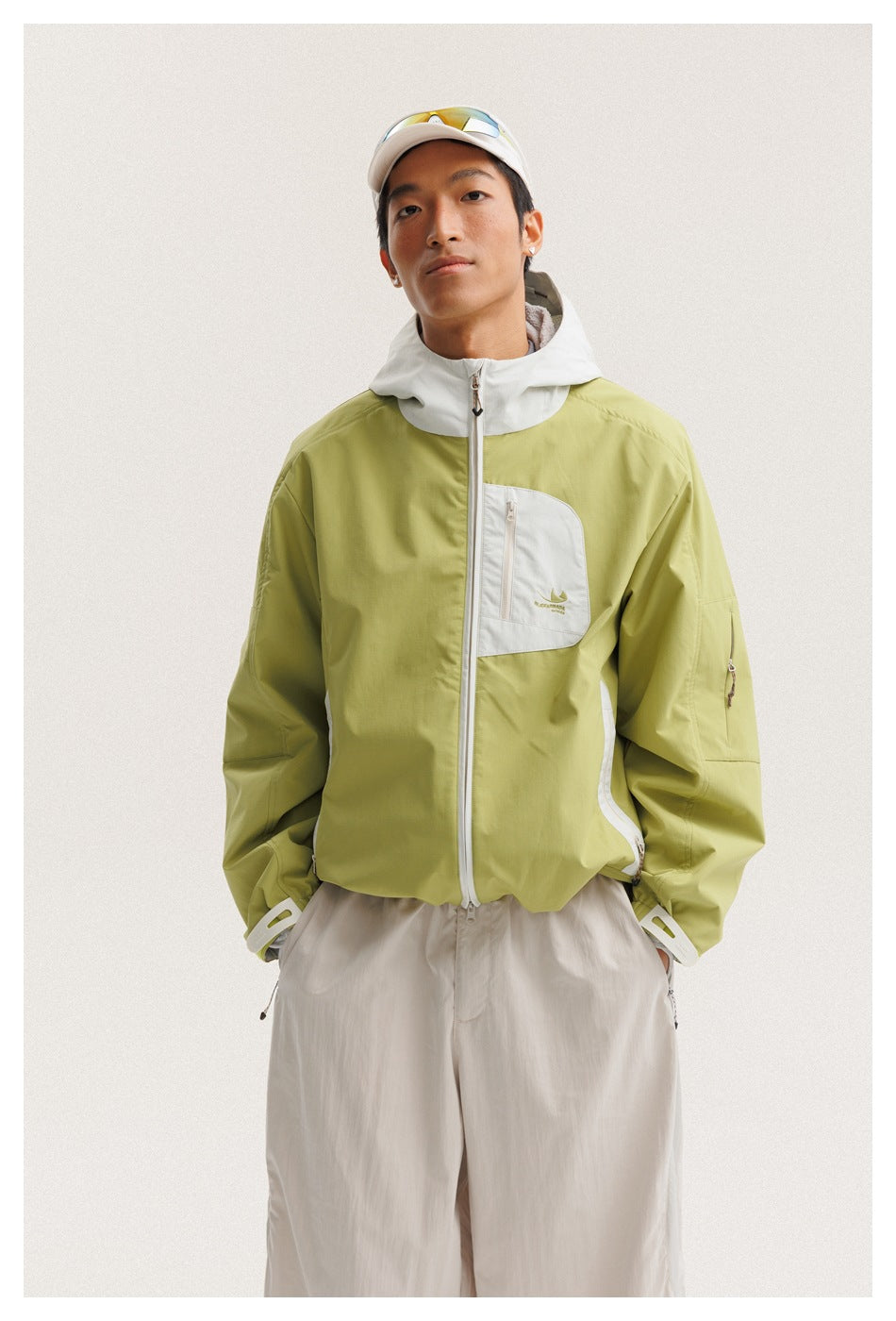 Front view of a man wearing a lime-green jacket with a white hood, trim and chest pocket.