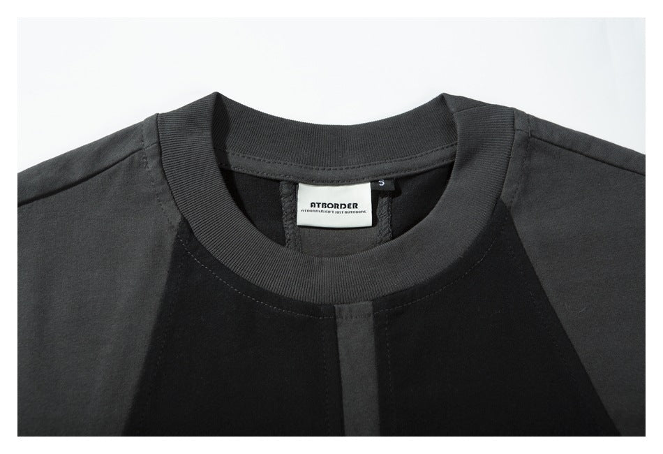 Close-up of the ribbed crew neck, shoulder seams, and sewn-in brand and size labels on the T-shirt.