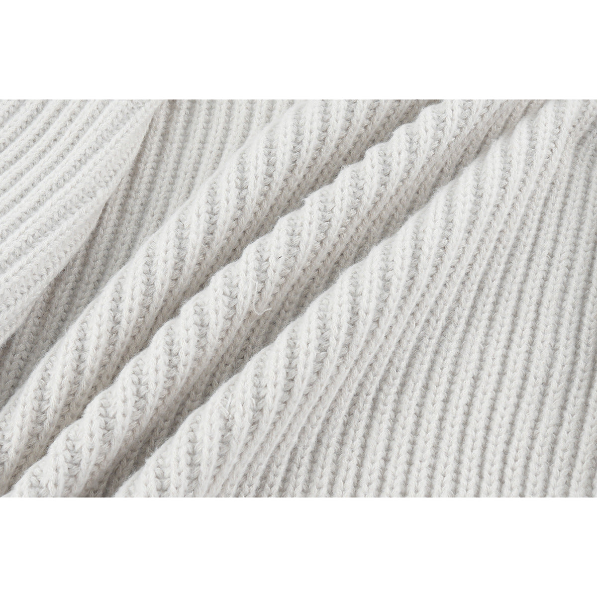 Macro view of the off-white cardigan's raised rib-knit texture.