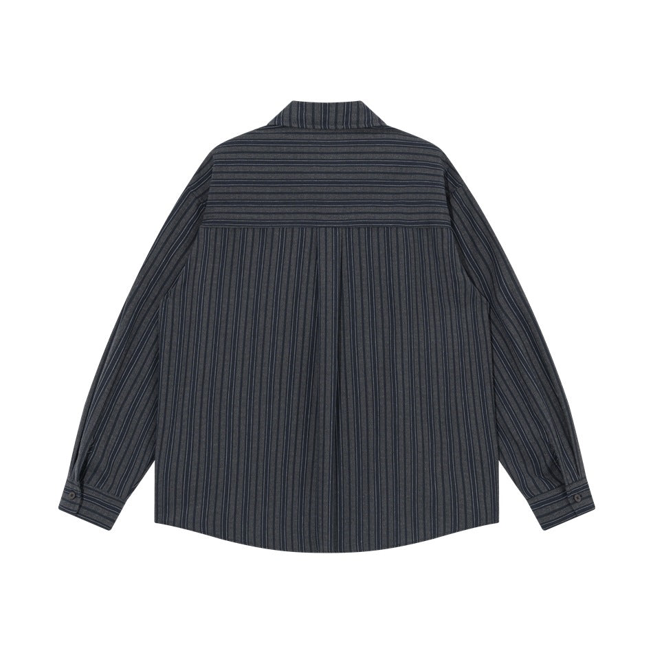 Back view of dark blue pinstriped shirt with horizontal-striped yoke and button cuffs, flat lay