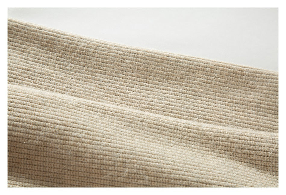 Close-up of beige rib-knit fabric showing fine horizontal ridges and a soft folded edge.