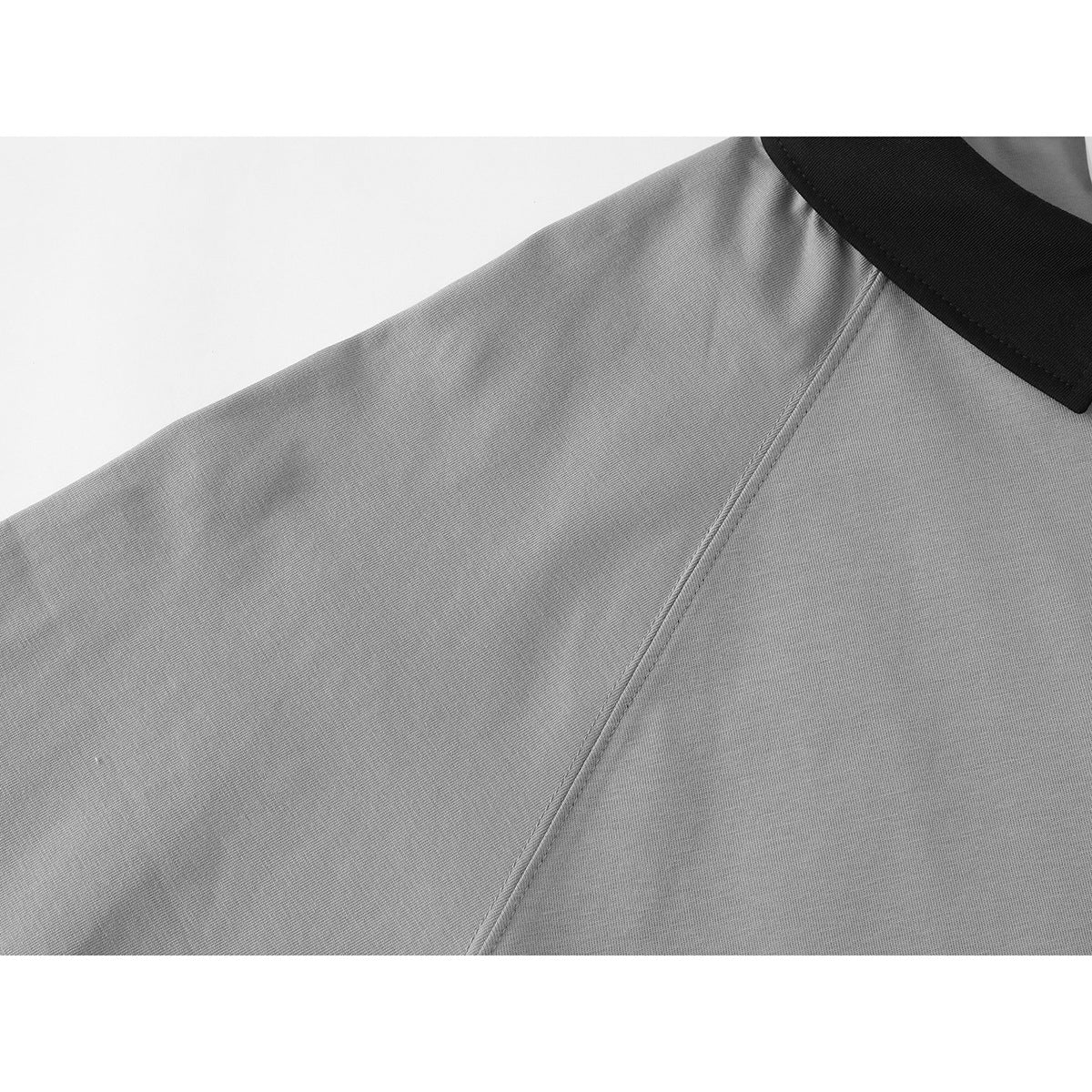 Close-up of the gray polo shirt's shoulder seam and black collar.