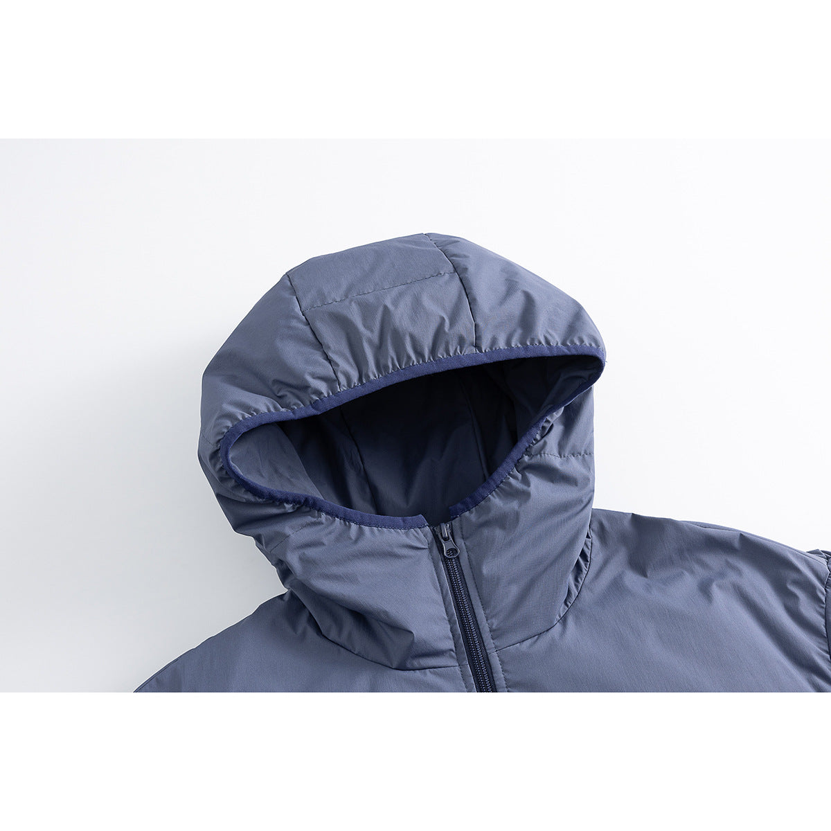 Close-up of a slate-blue padded jacket's hood, dark lining, and front zipper.