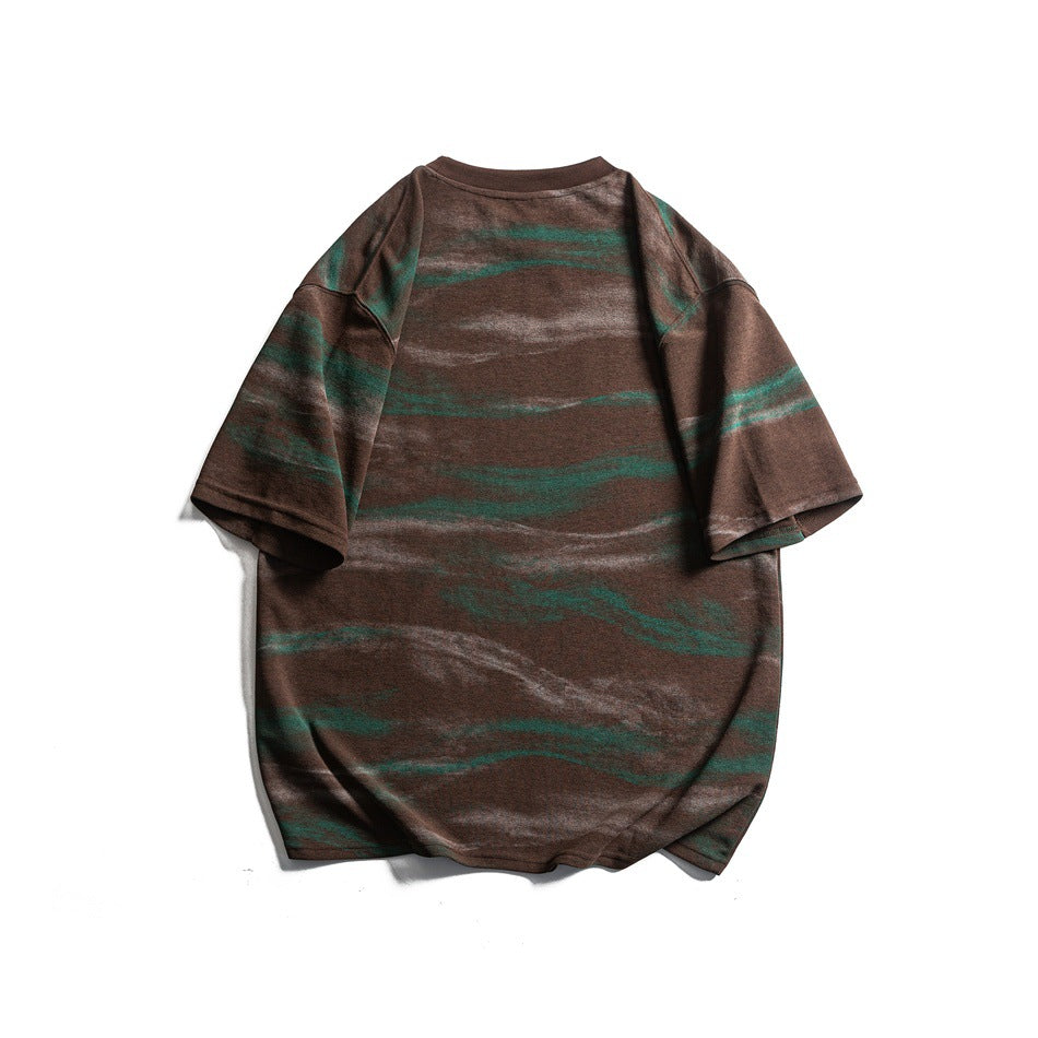 Back view of a brown oversized T-shirt with irregular green and pale gray horizontal stripes.