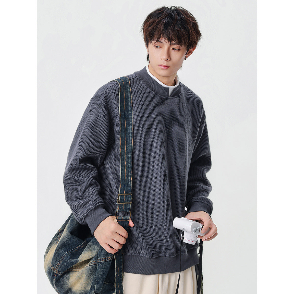 Model wearing an oversized charcoal gray ribbed sweatshirt with a stand collar and ribbed cuffs and hem.