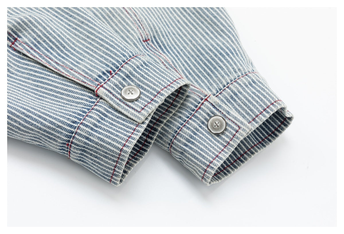 Close-up of two buttoned cuffs on a blue-and-white striped garment with red seam stitching.