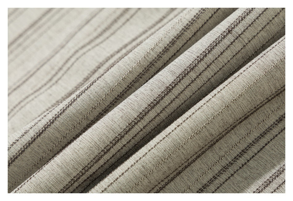 Close-up showing the beige shirt fabric and its thin, irregular dark stripes.