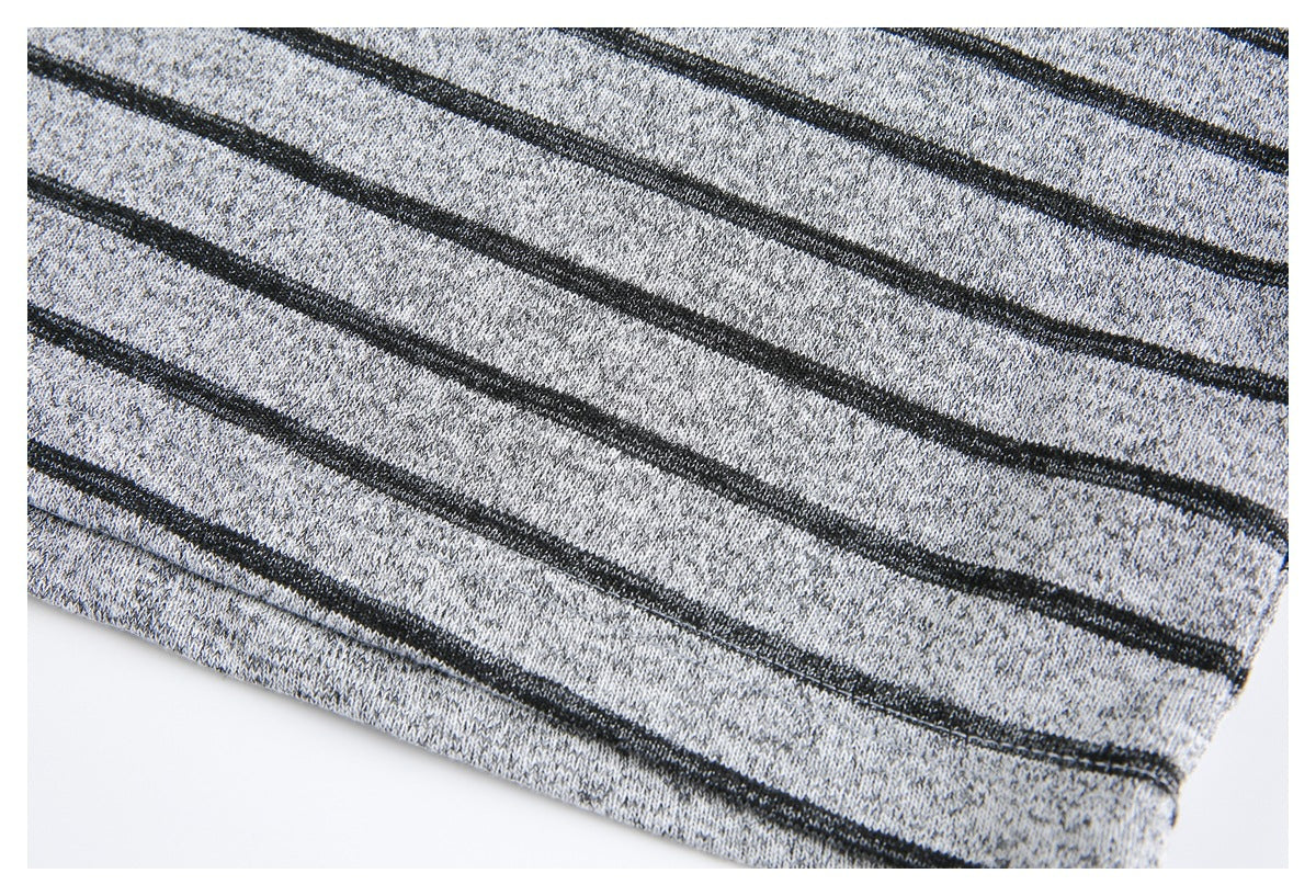 Close-up of the gray knit garment's narrow black stripes and stitched hem.