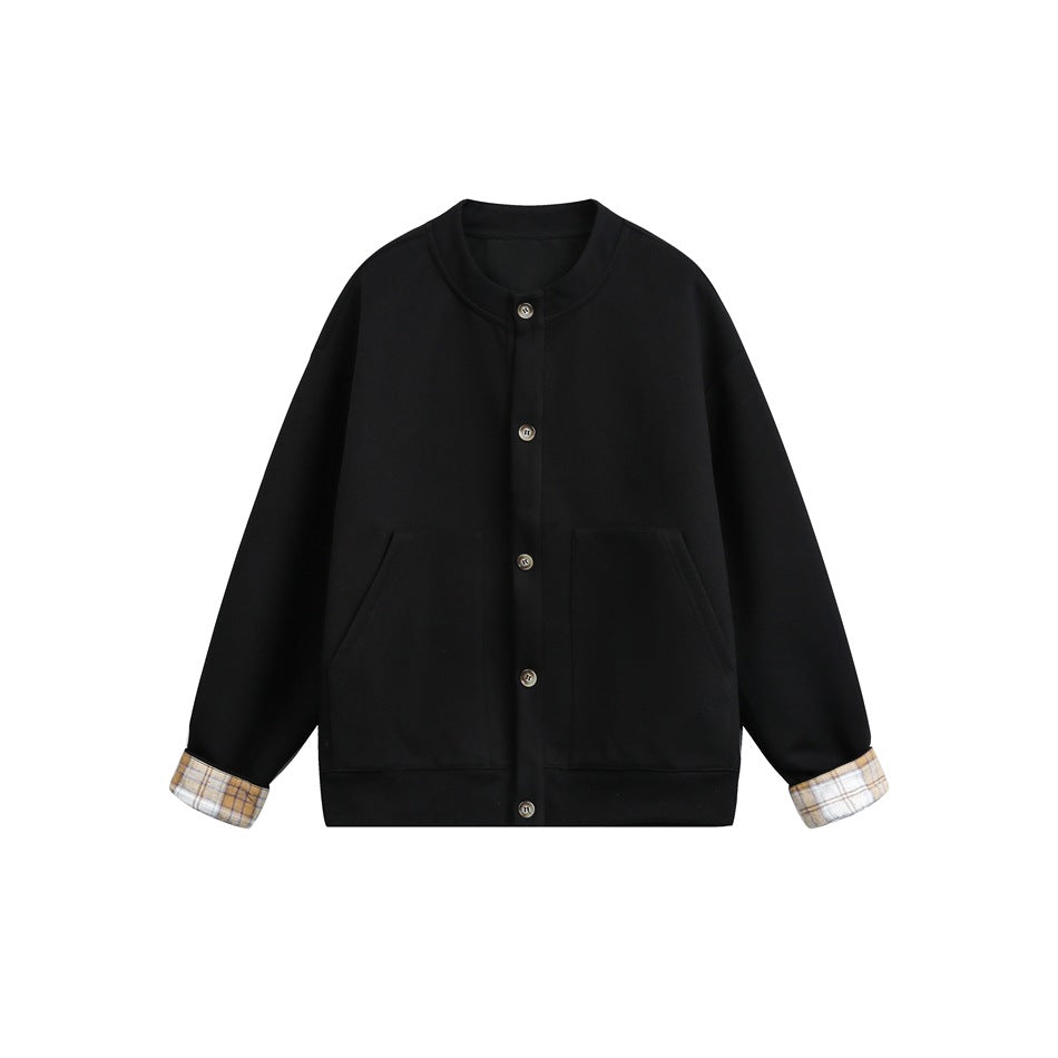 Black button-front jacket with stand collar, front pockets and beige plaid cuffs, flat lay
