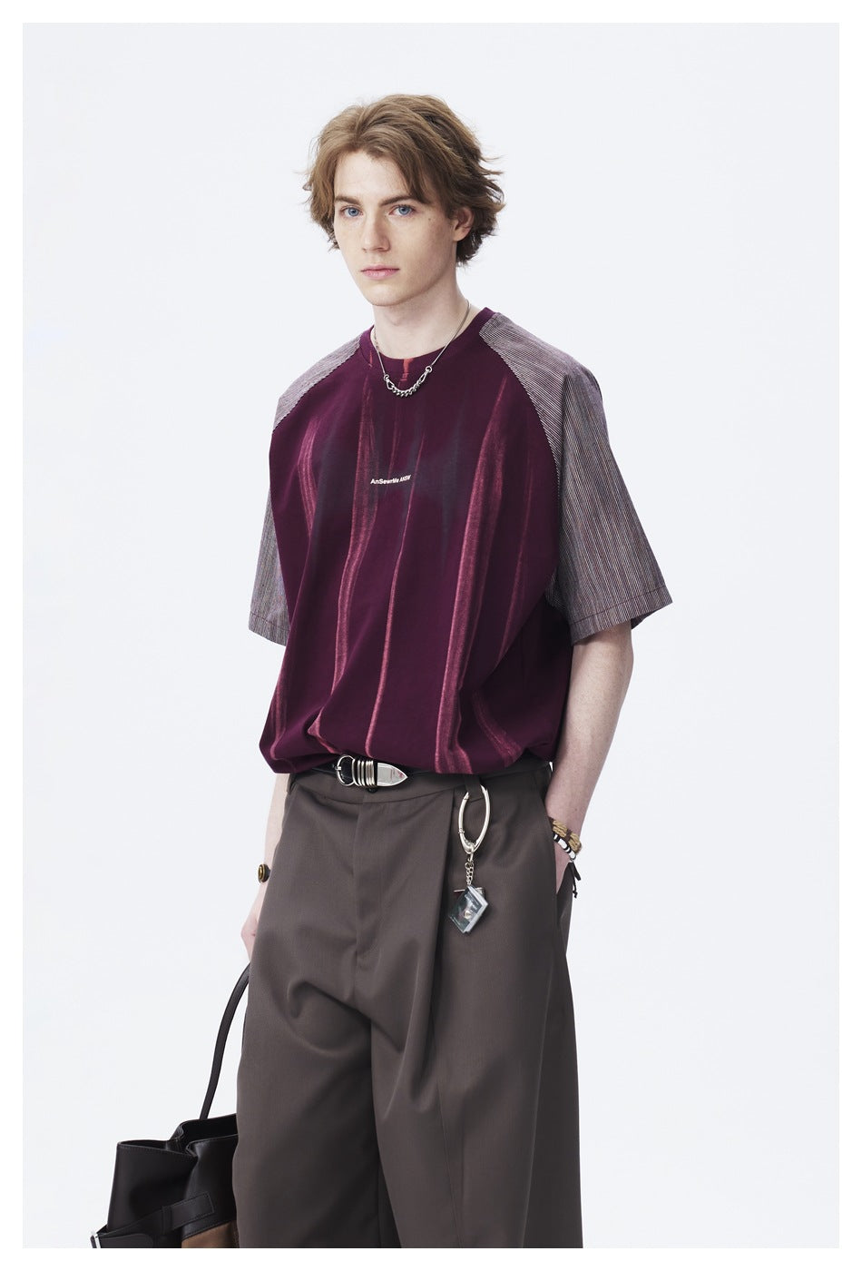 Closer view of a model wearing a burgundy shirt with vertical accents and contrasting gray striped sleeves.