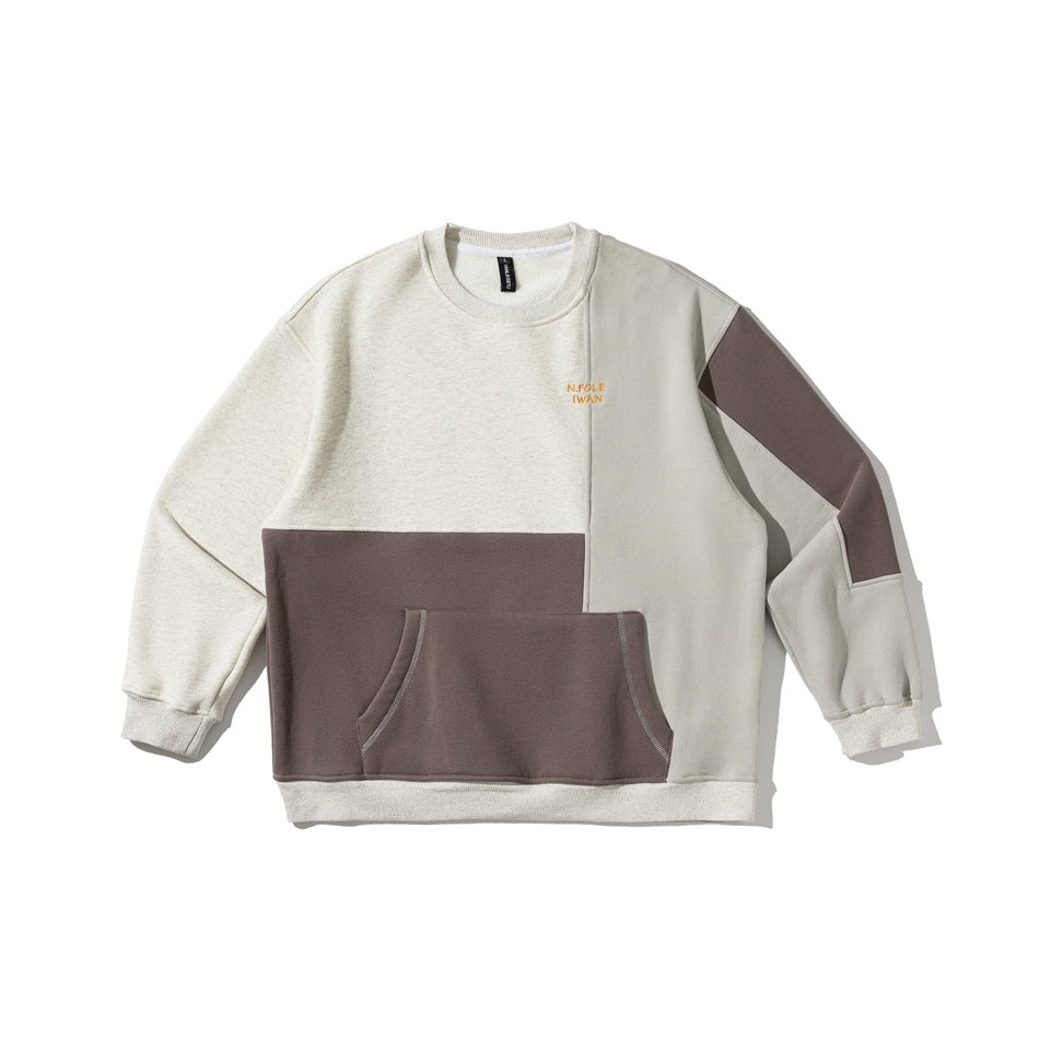 Flat-lay of a color-block crewneck sweatshirt in oatmeal, taupe-brown and light gray with a front pocket