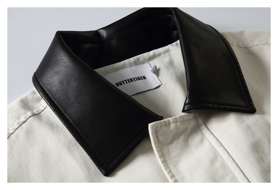 Close-up of an off-white jacket with a wide black collar and a visible inner brand label.
