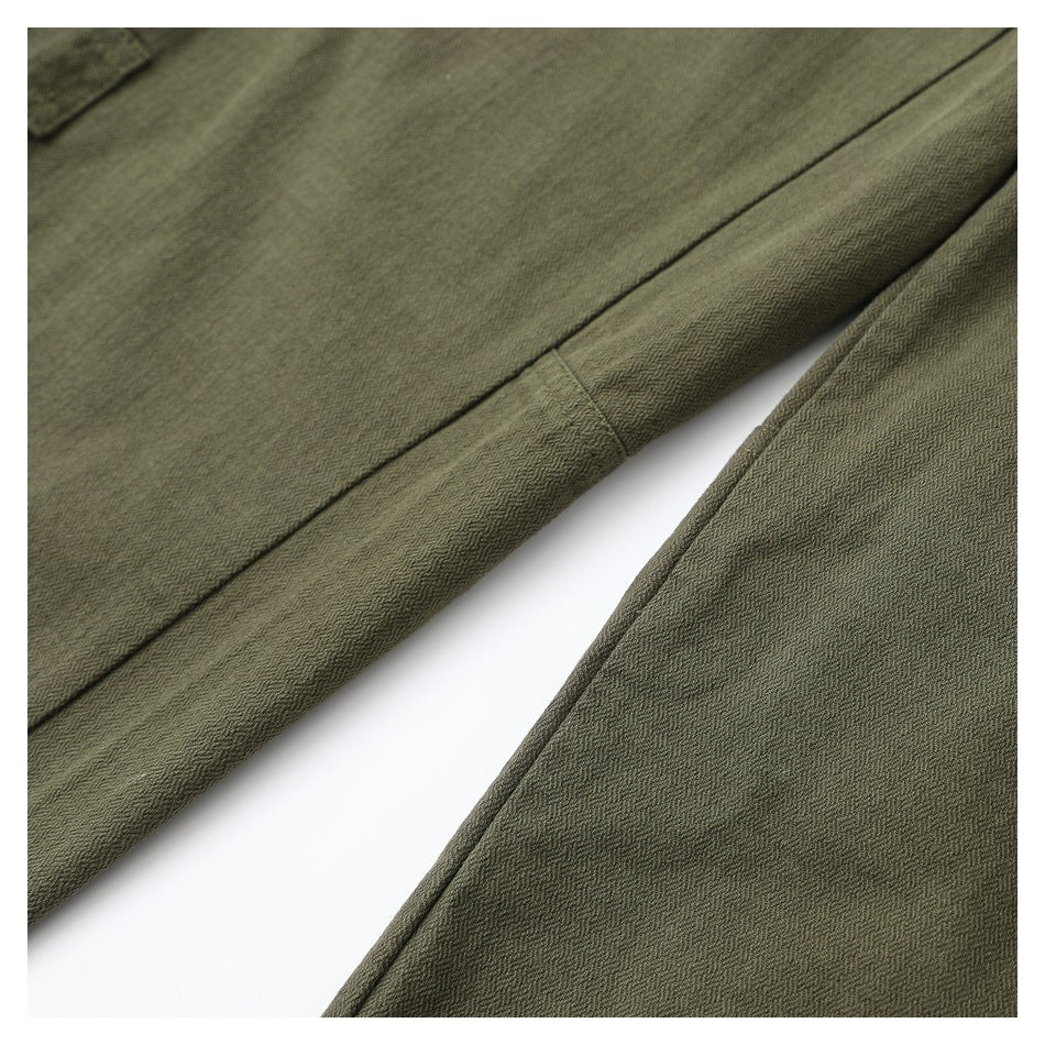 Close-up of olive pant legs showing the fabric texture and stitched seam.