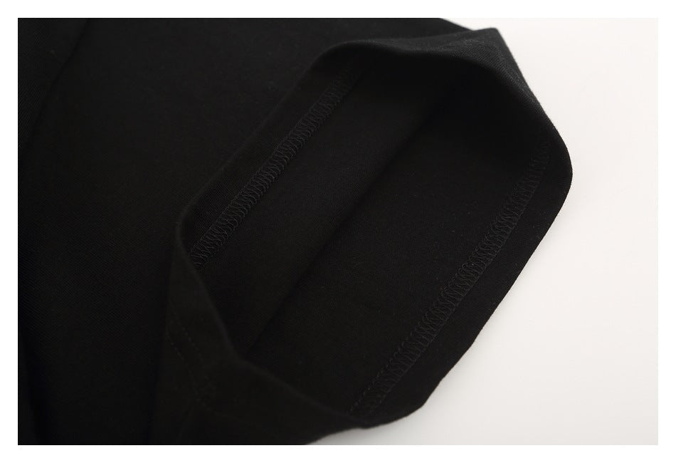 Close-up of a black T-shirt sleeve opening and its visible overlock stitching.