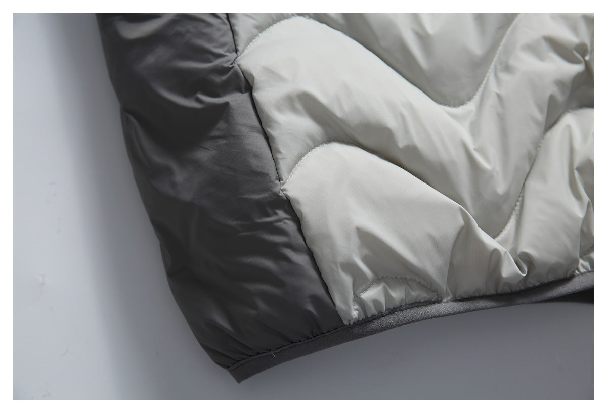 Close-up of contrasting charcoal and light gray quilted panels with dark edging.