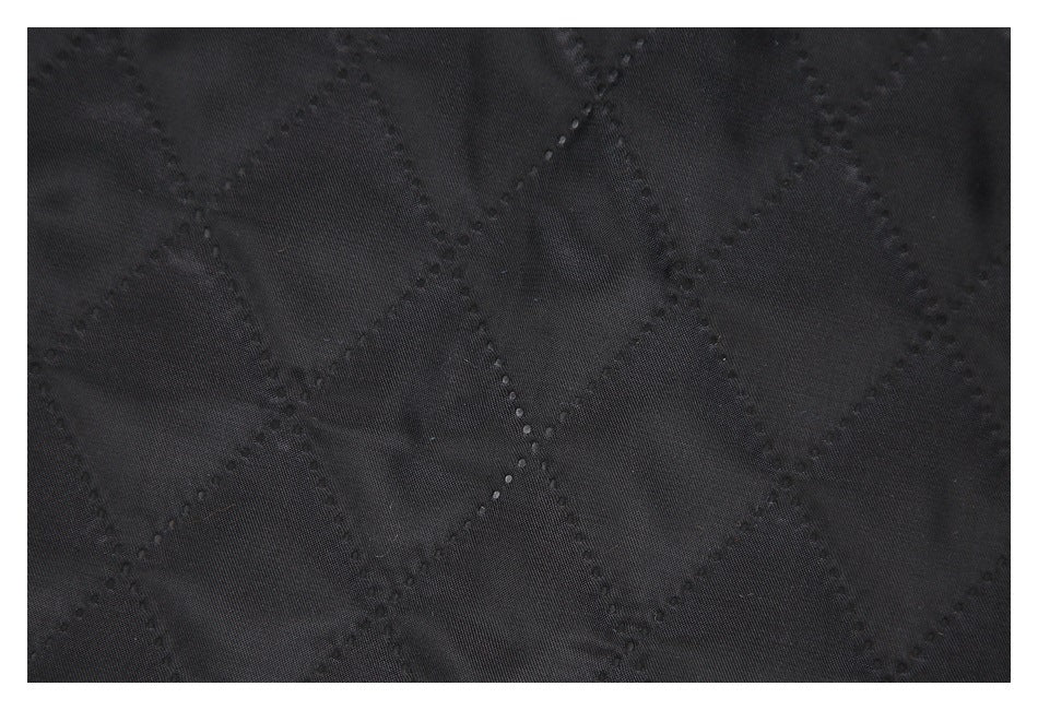 Close-up of black fabric with a stitched diamond quilting pattern.