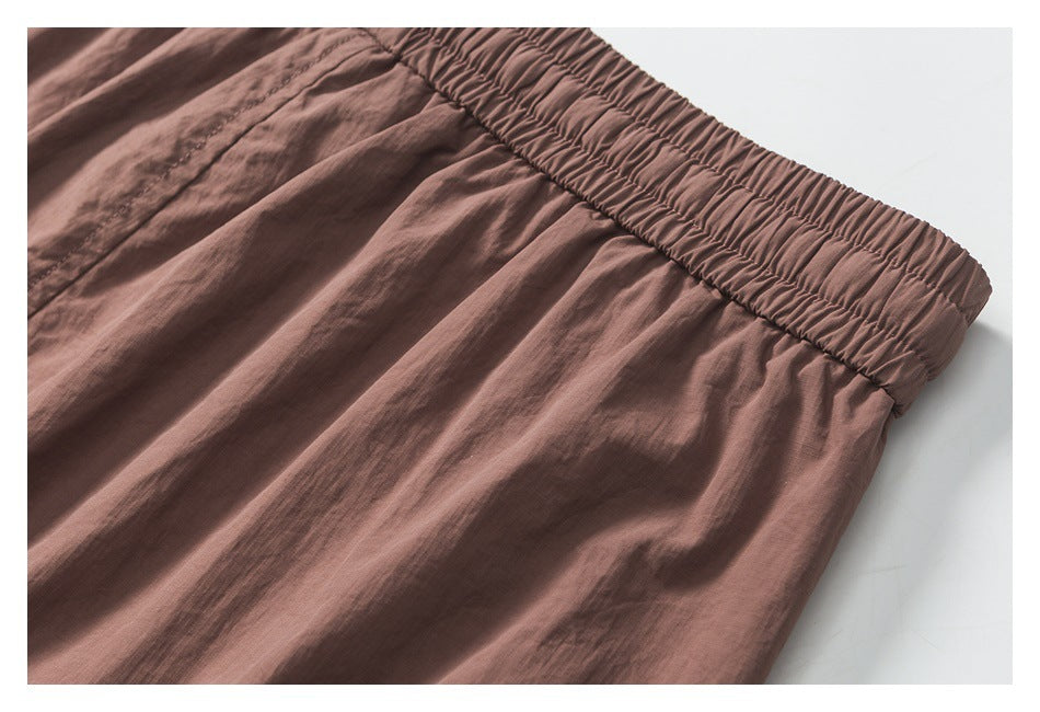 Close-up of dusty mauve shorts showing the gathered elastic waistband and stitched fabric.