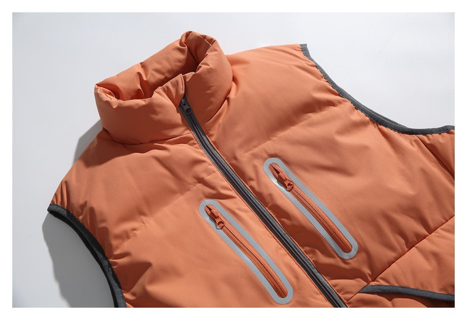 Close-up of a coral-orange vest showing its raised collar, front zipper, reflective-edged chest pockets and dark trim.
