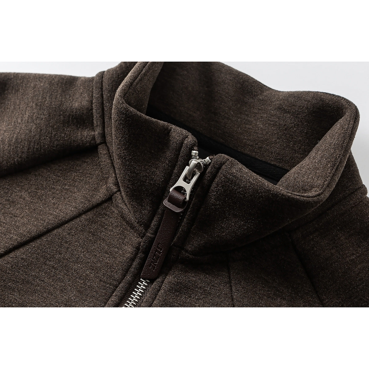 Close-up of a dark brown pullover's raised collar and short silver zipper.