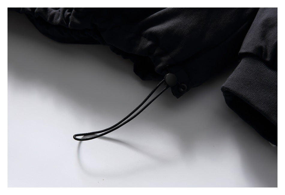 Close-up of the black jacket's adjustable drawcord and toggle at the hem.