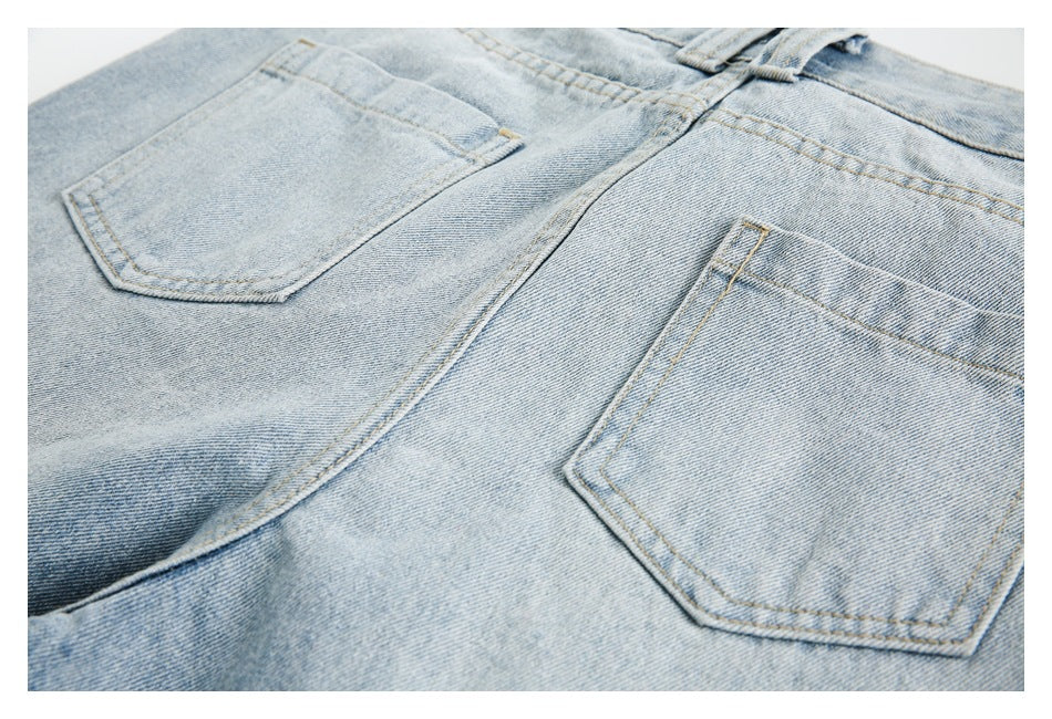 Close-up of the back of light blue jeans, showing two patch pockets and the center seam.