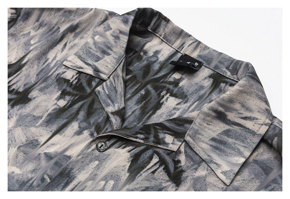 Close-up of a gray and black abstract-print shirt collar, lapel, and front button.