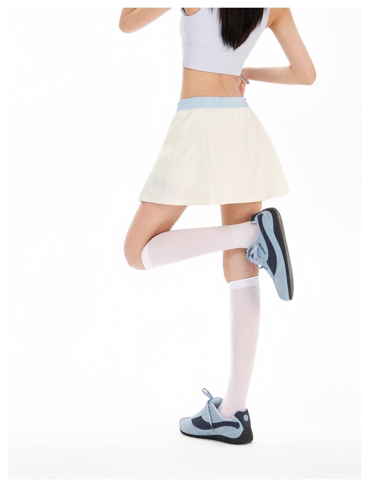 Model wearing the ivory flared skirt with a light-blue waistband, shown from the back.