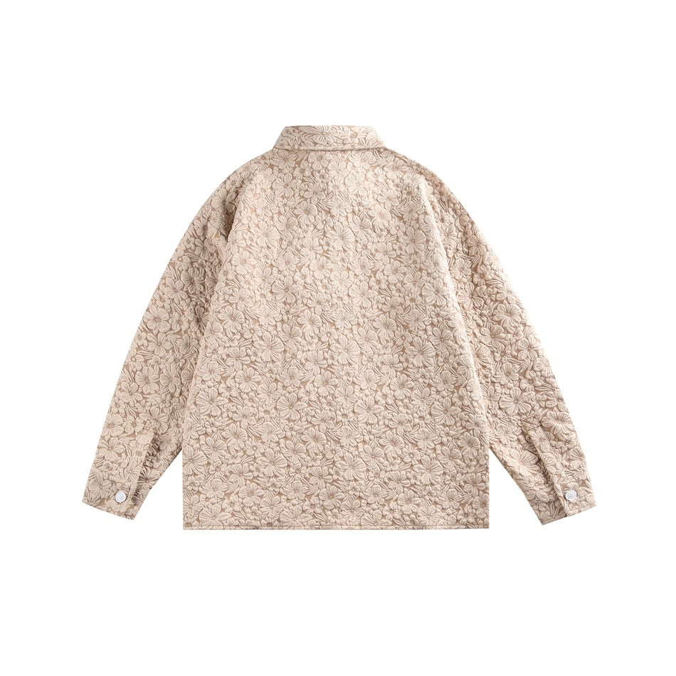 Back view of a beige jacket covered in a dense floral pattern, with buttoned cuffs.