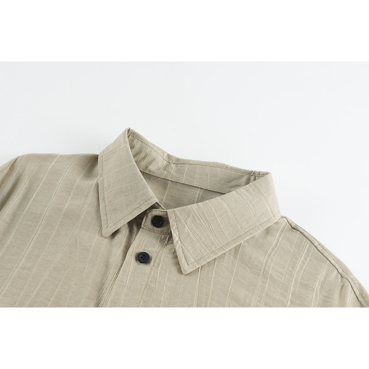 Close-up of a beige pinstriped shirt collar, neckline, and dark buttons.