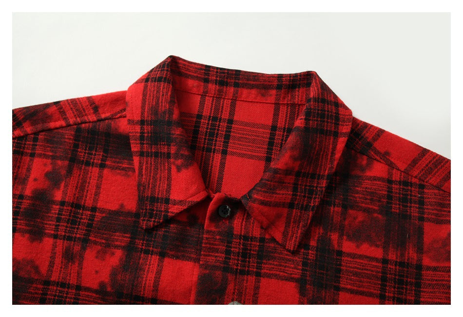 Close-up of the red-and-black plaid shirt's pointed collar and top button.