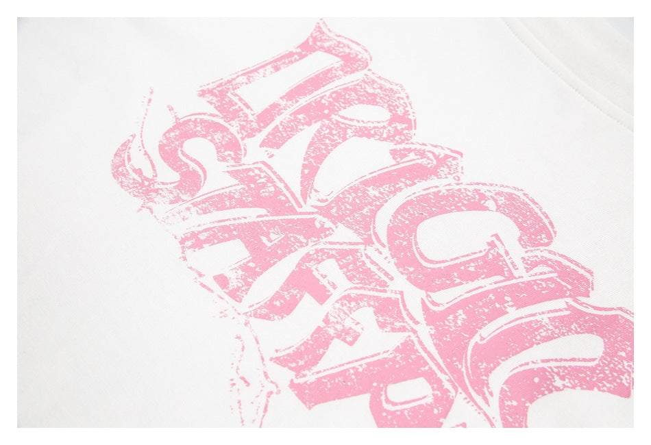 Angled close-up of the distressed pink graphic printed on white T-shirt fabric.