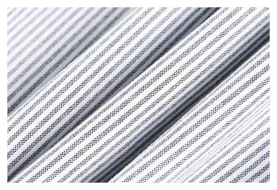 Macro view of folded white fabric with narrow navy stripes and a textured weave.