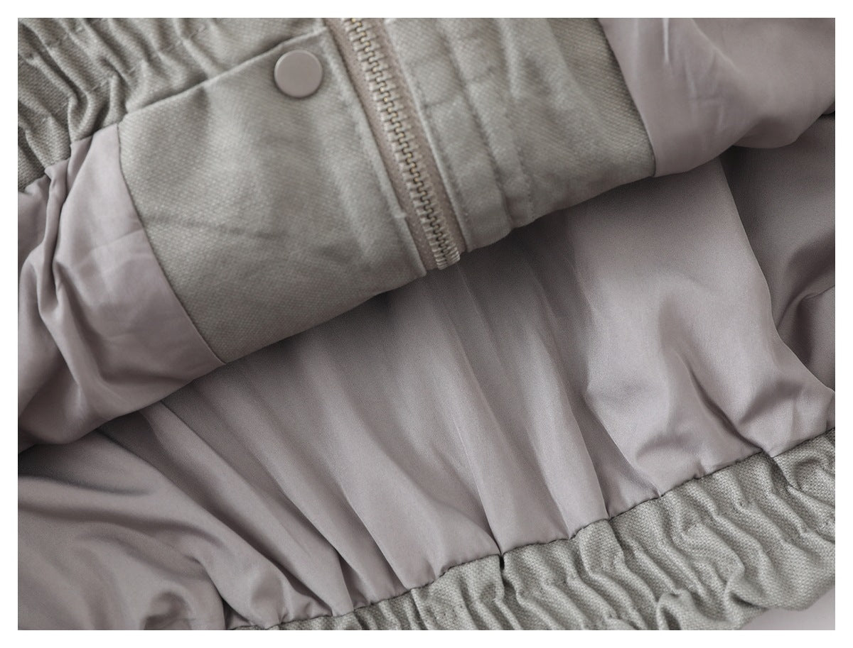 Close-up of the jacket's pale lining, zipper, snap, and gathered edge.