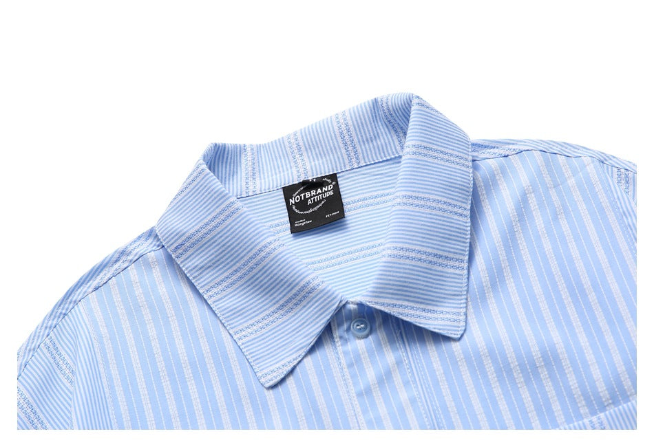 Laid-flat light blue shirt shown from the front, with a pointed collar and mixed vertical and horizontal stripes.