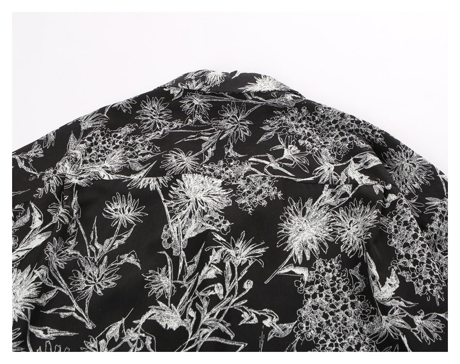 Close-up of the back collar and yoke of a black shirt with white floral print.