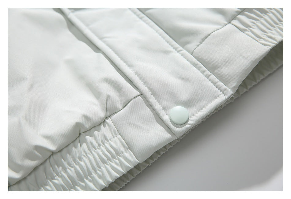 Close-up of a white jacket's snap-fastened front placket and gathered hem.