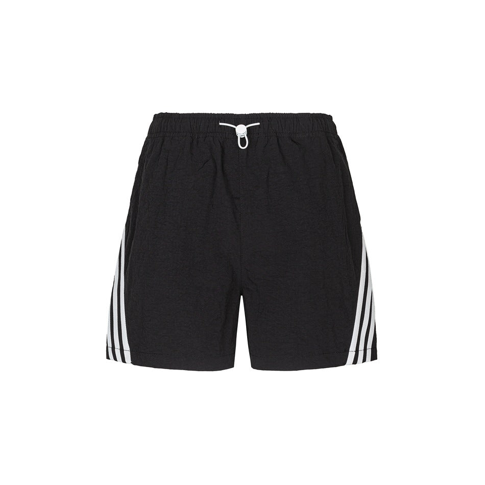 Black woven shorts with an elastic waistband, white drawcord toggle and white diagonal side stripes