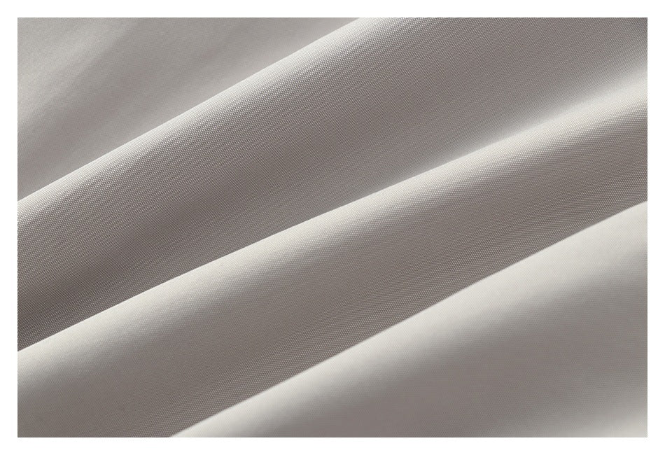 Close-up of light gray fabric draped in diagonal folds, showing its fine surface texture.