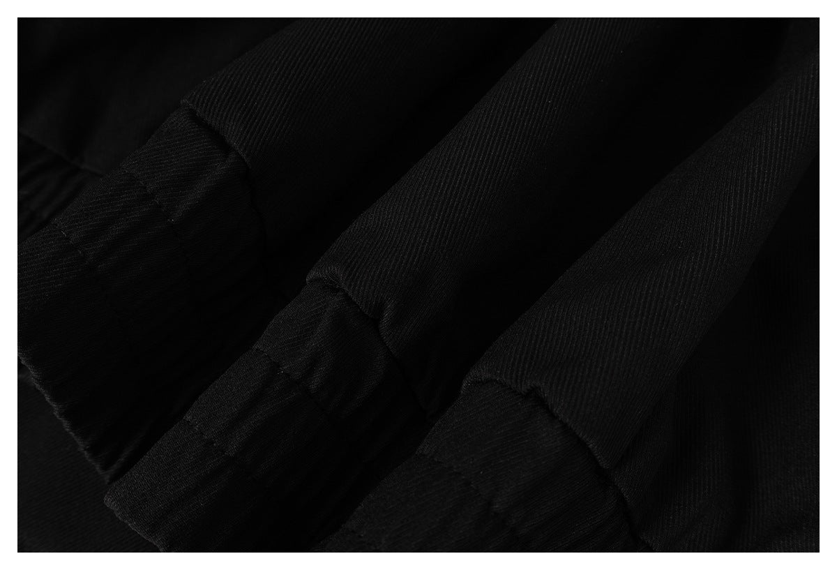 Very dark close-up of black fabric with ribbed and textured sections.