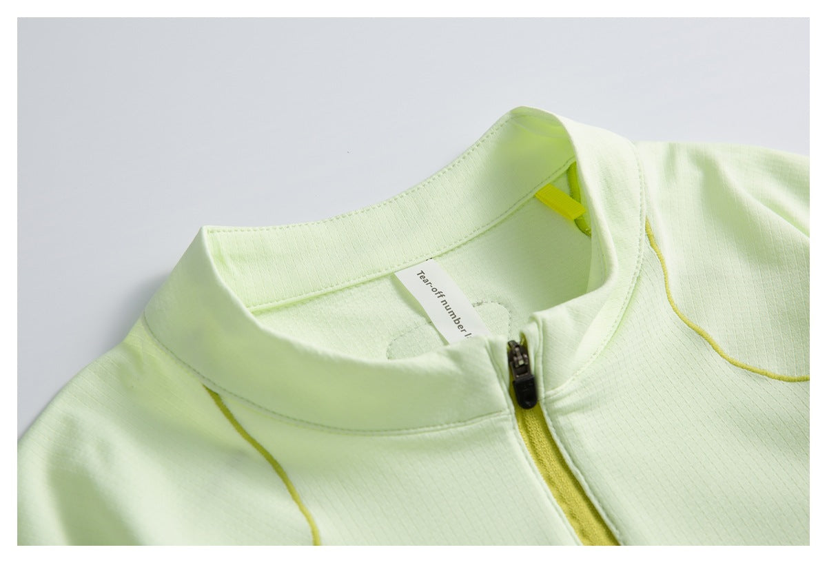 Close-up of a pale lime top's stand collar, front zipper, and inner neck label.