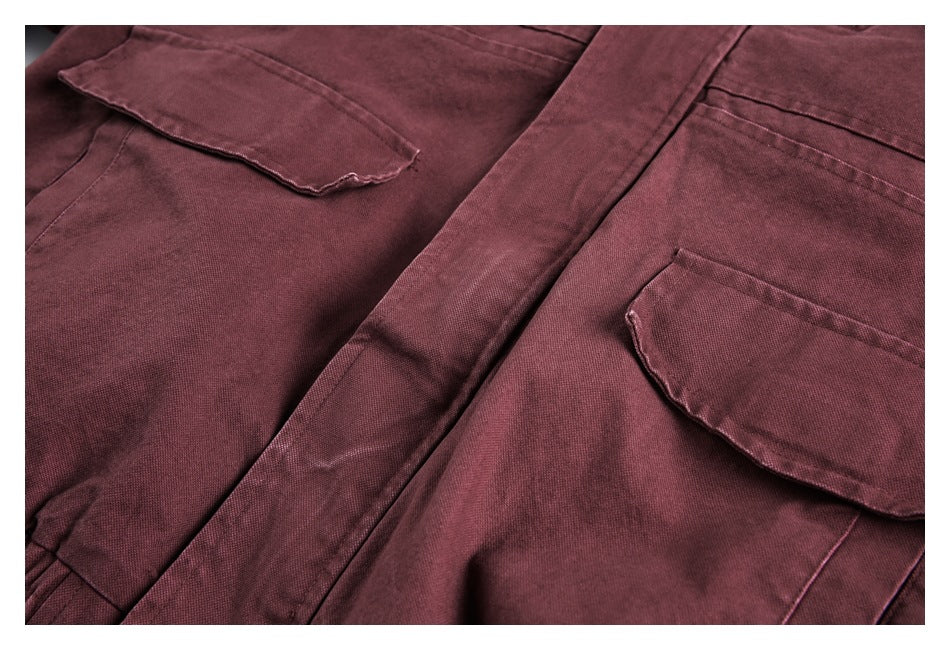 Close-up showing two flap pockets and a central placket on a burgundy garment.