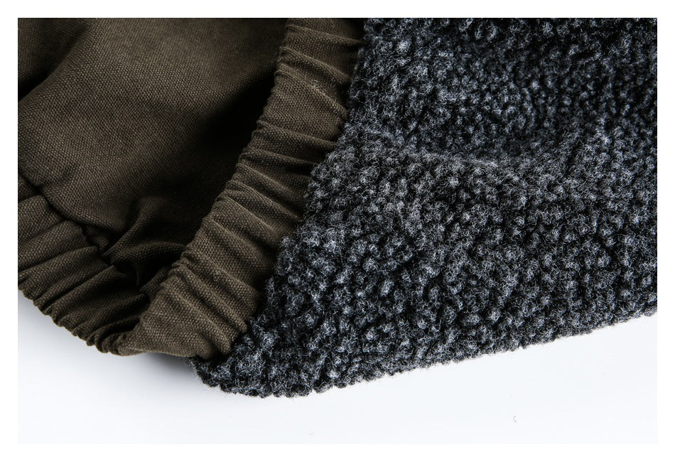 Close-up of the garment's dark charcoal textured edge beside gathered brown fabric lining.