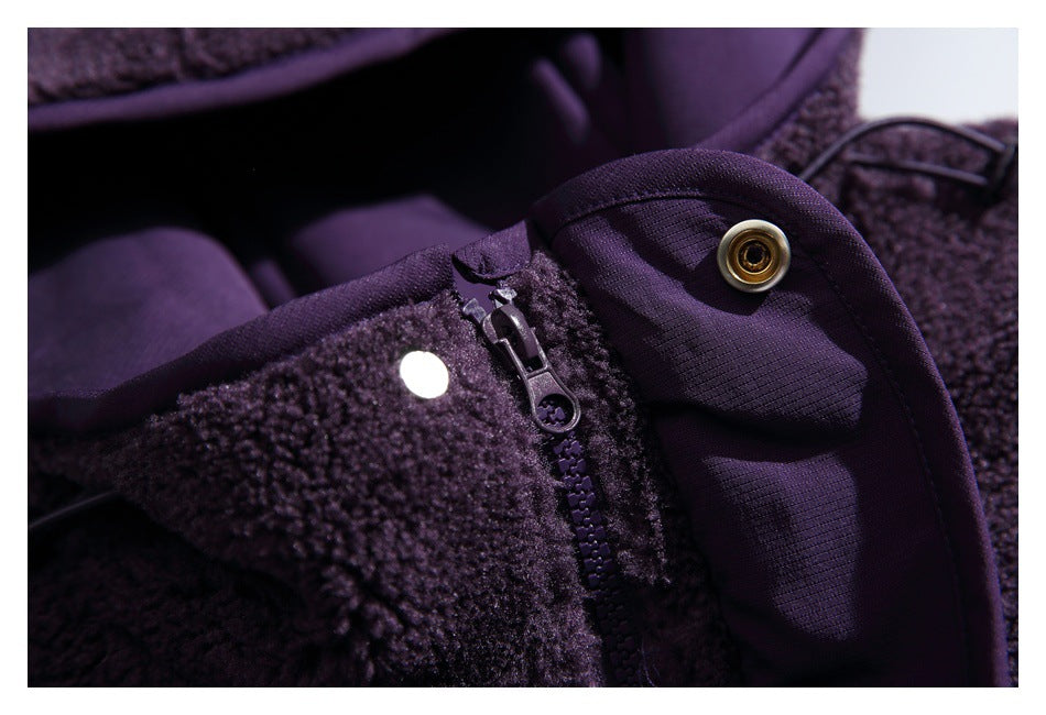 Close-up of a deep purple jacket's front zipper, snap fastener, and fuzzy outer fabric.