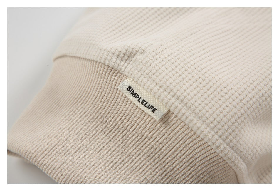 Close-up of a sewn SIMPLELIFE label beside the cream top's ribbed trim.