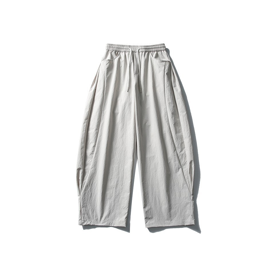 Off-white wide-leg drawstring pants, front flat lay, with crinkled fabric and rounded legs