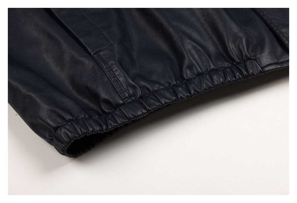 Close-up of the black jacket's gathered elastic hem and lower side seam.