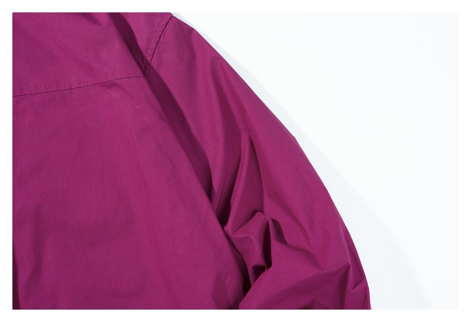 Close-up of a deep magenta garment shoulder and sleeve seam.
