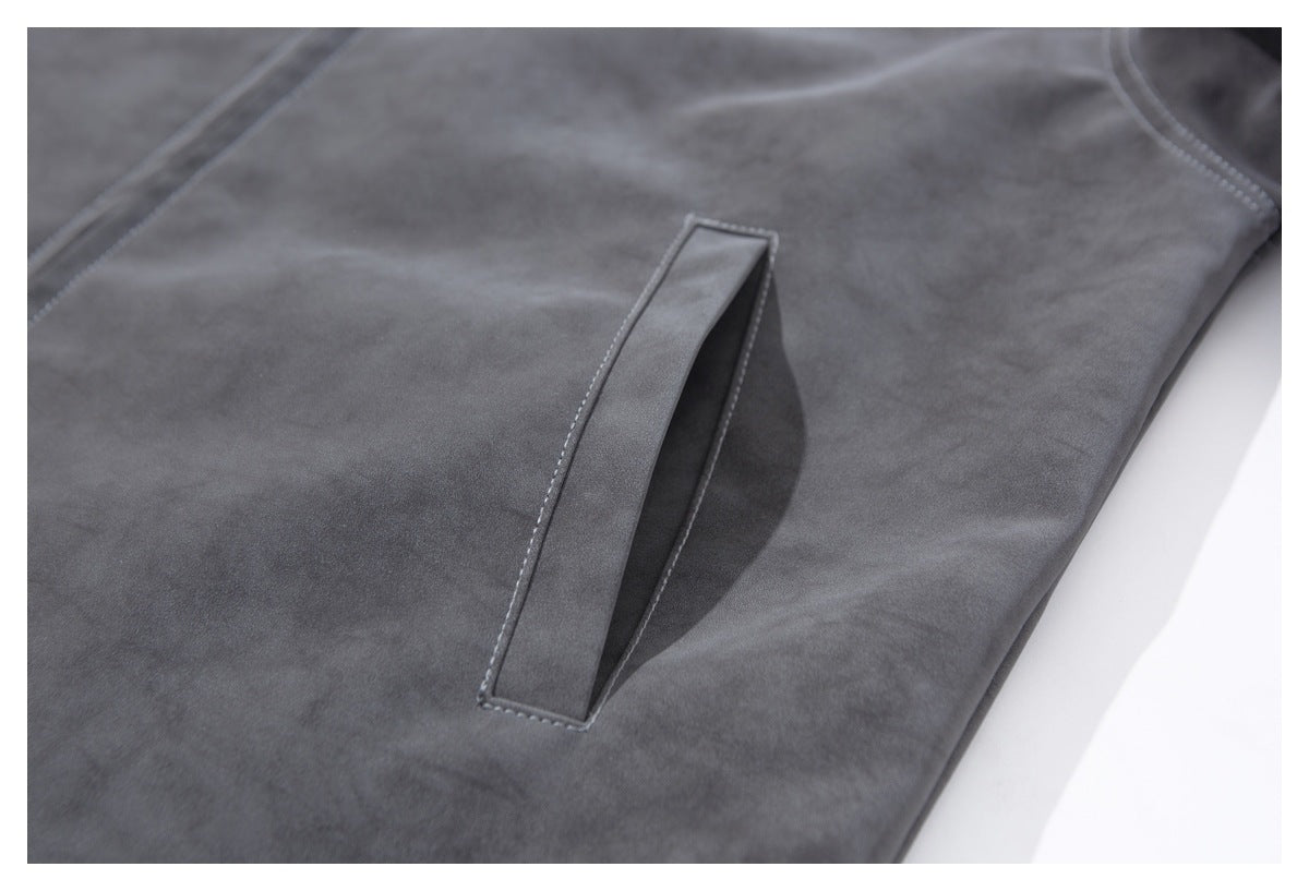 Close-up of a slanted welt pocket on the dark charcoal jacket.